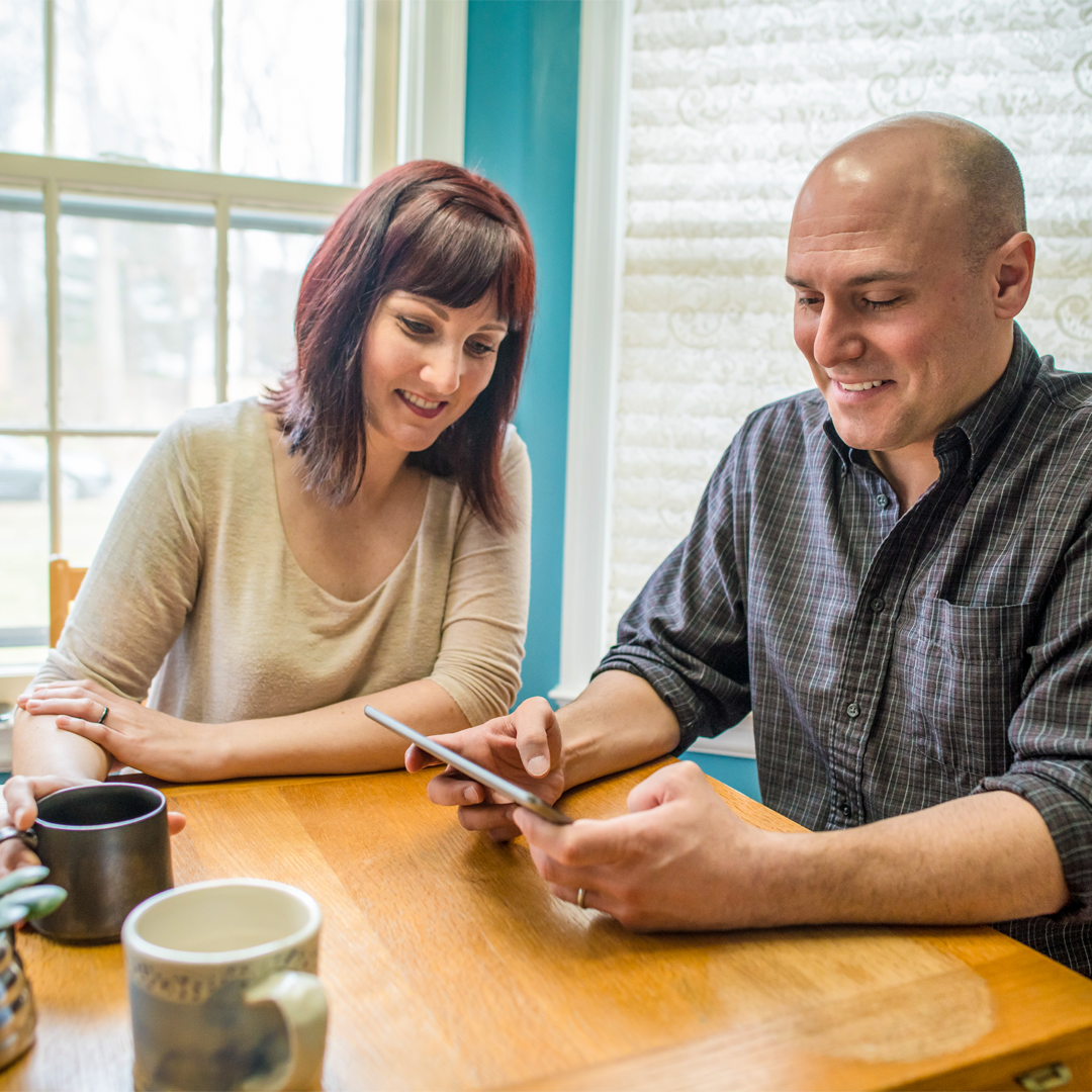 Couple shopping for windows on tablet at table