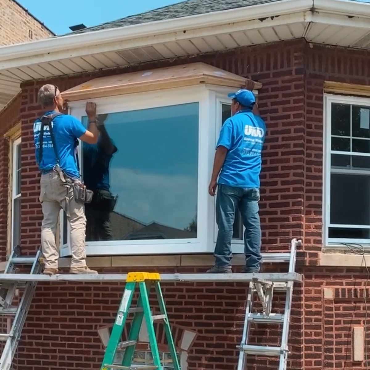 Window installers installing a new bay window