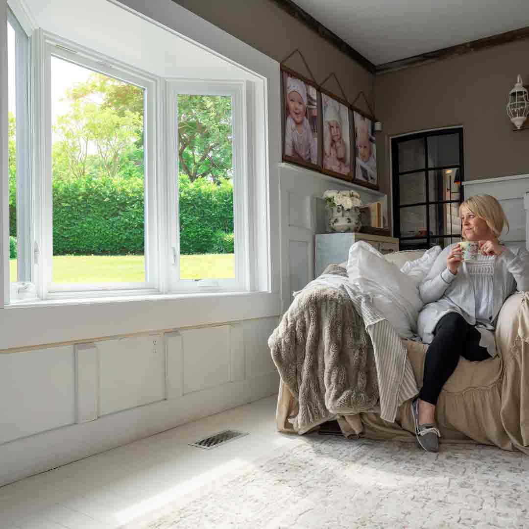 Lady drinking coffee by a bay window