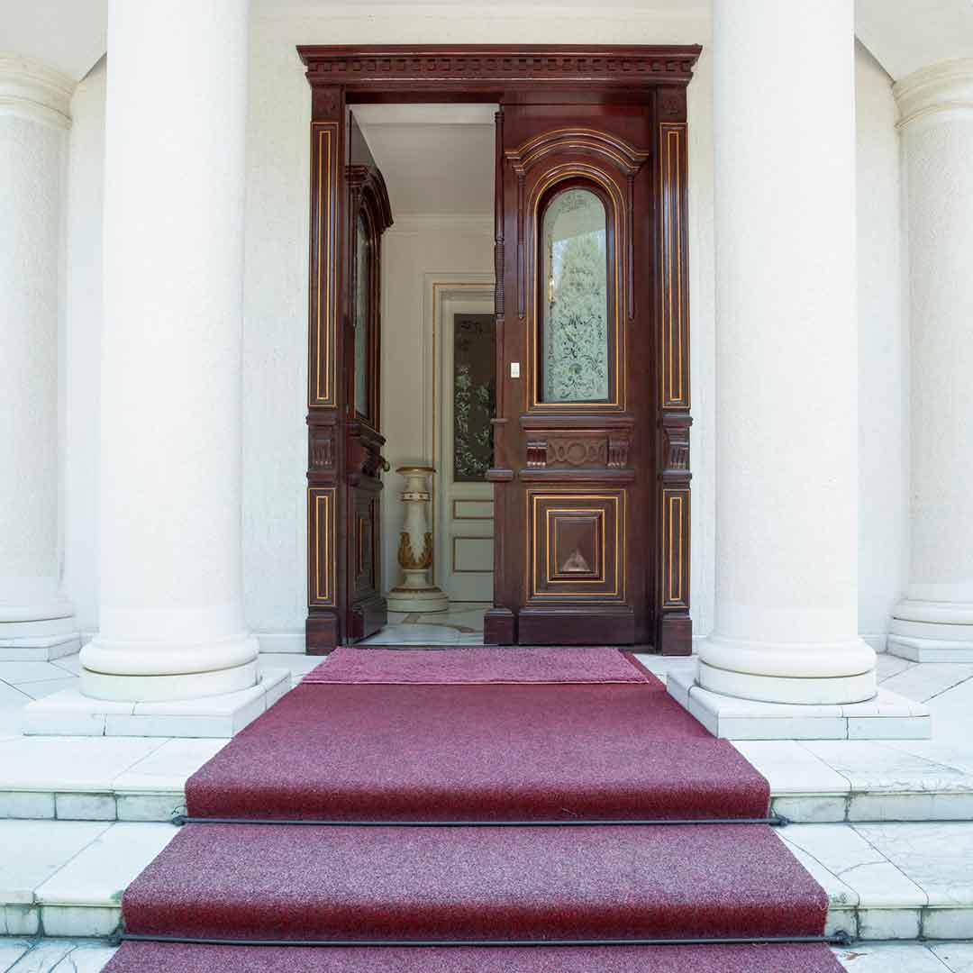 beautiful, ornate double front door, standing between two pillars