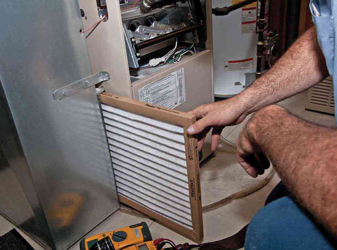 man replacing furnace filter