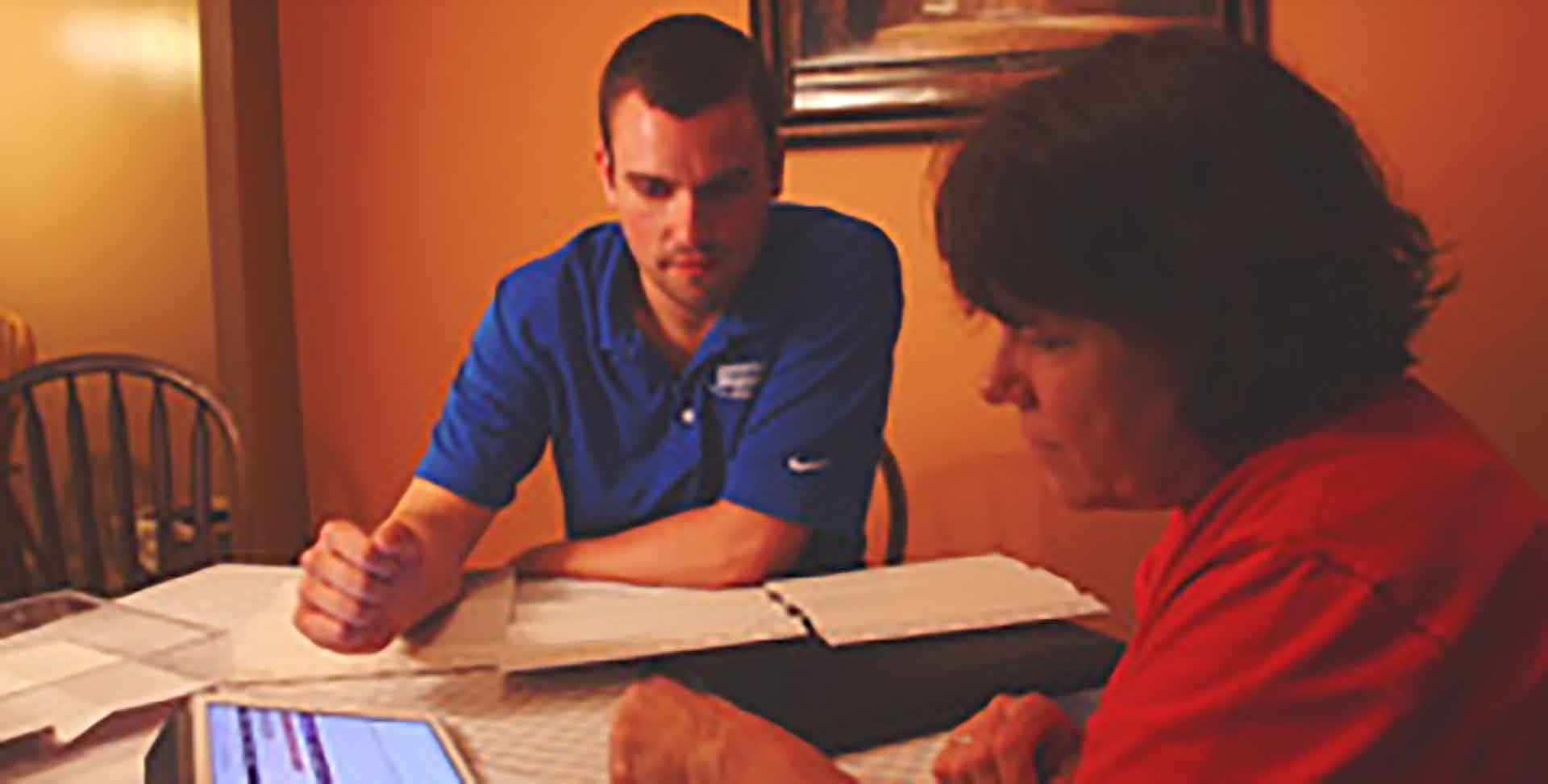 Sales representative at table with homeowner